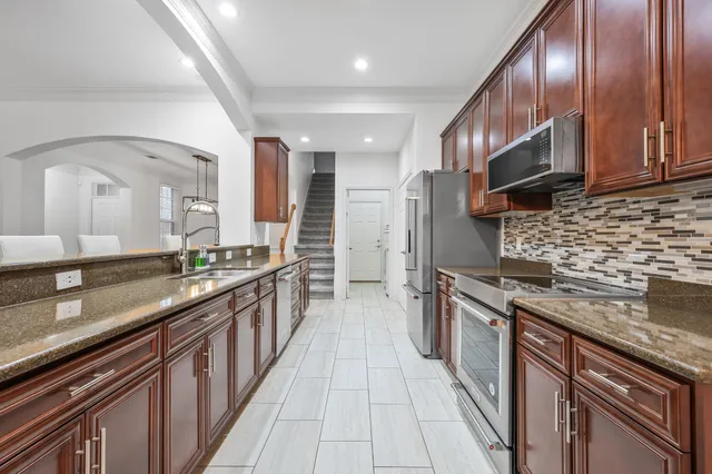 a large kitchen with stainless steel appliances granite countertop a lot of counter space and wooden floor