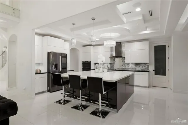 a kitchen with stainless steel appliances granite countertop a sink and a refrigerator