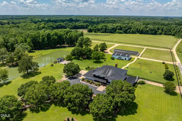 an aerial view of a house with a garden and lake view