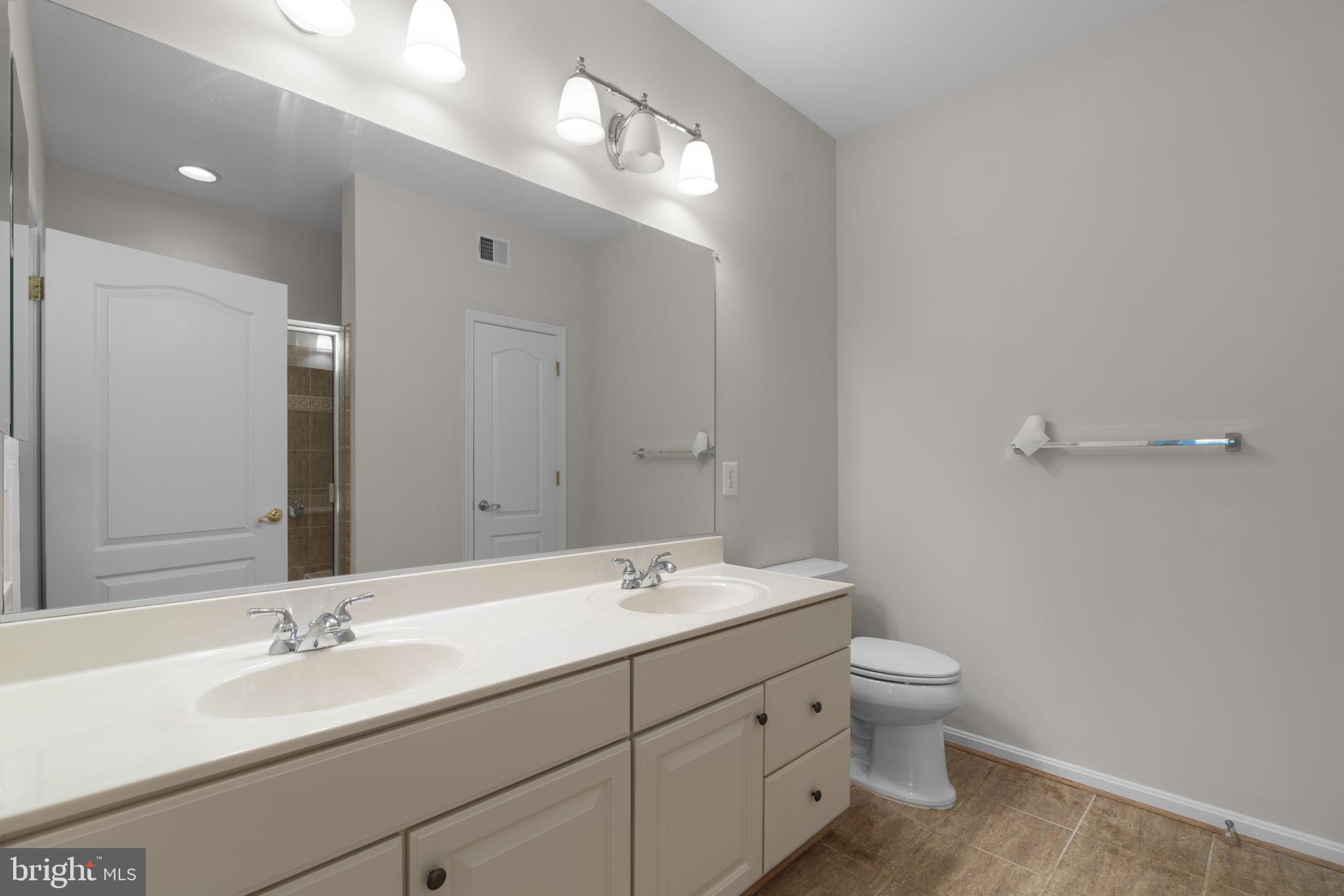 7315 Maplecrest Road, Unit 104 Elkridge, MD 21075 - Photo 34 of 58 a bathroom with a double vanity sink and a mirror