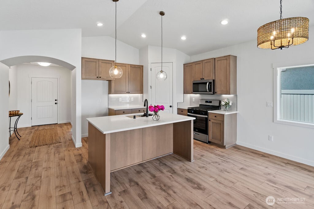 231 Shrute Road Prosser, WA 99350 - Photo 9 of 36 a large kitchen with kitchen island a stove a sink a refrigerator and a wooden floor