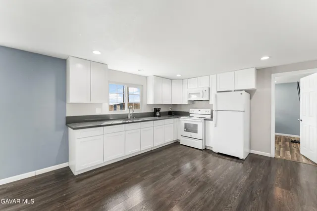 a kitchen with white cabinets and white appliances