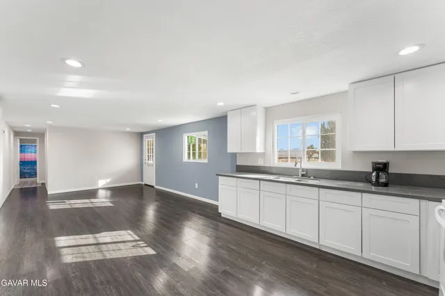 a view of empty room with wooden floor and windows