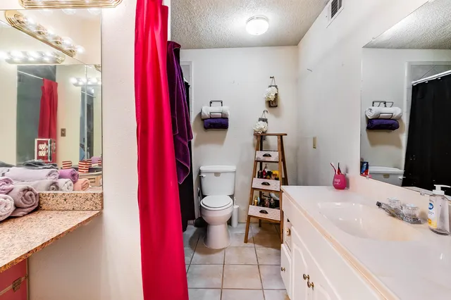 a bathroom with a sink vanity mirror and toilet