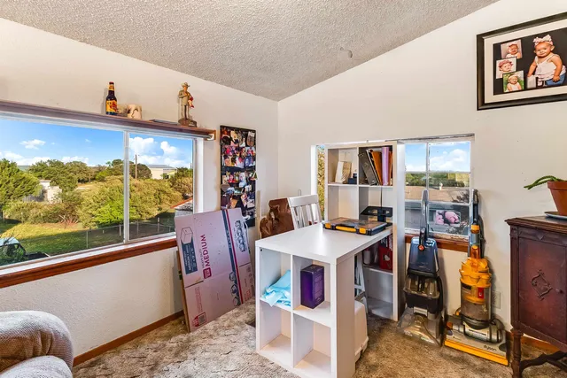 a view of a workspace with furniture and a window