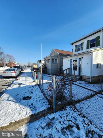 a backyard of a house with wooden fence and large windows