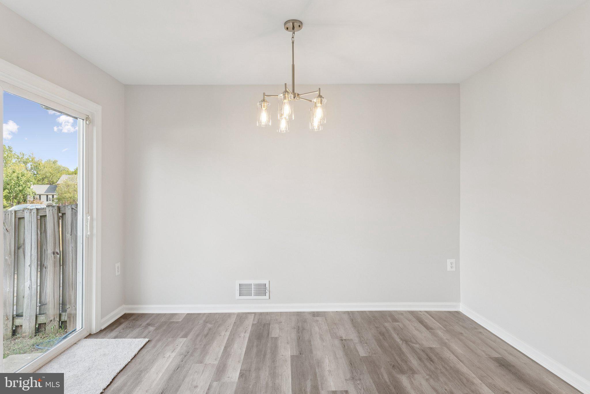 7408 Emerald Drive Manassas, VA 20109 - Photo 11 of 44 an empty room with wooden floor and windows