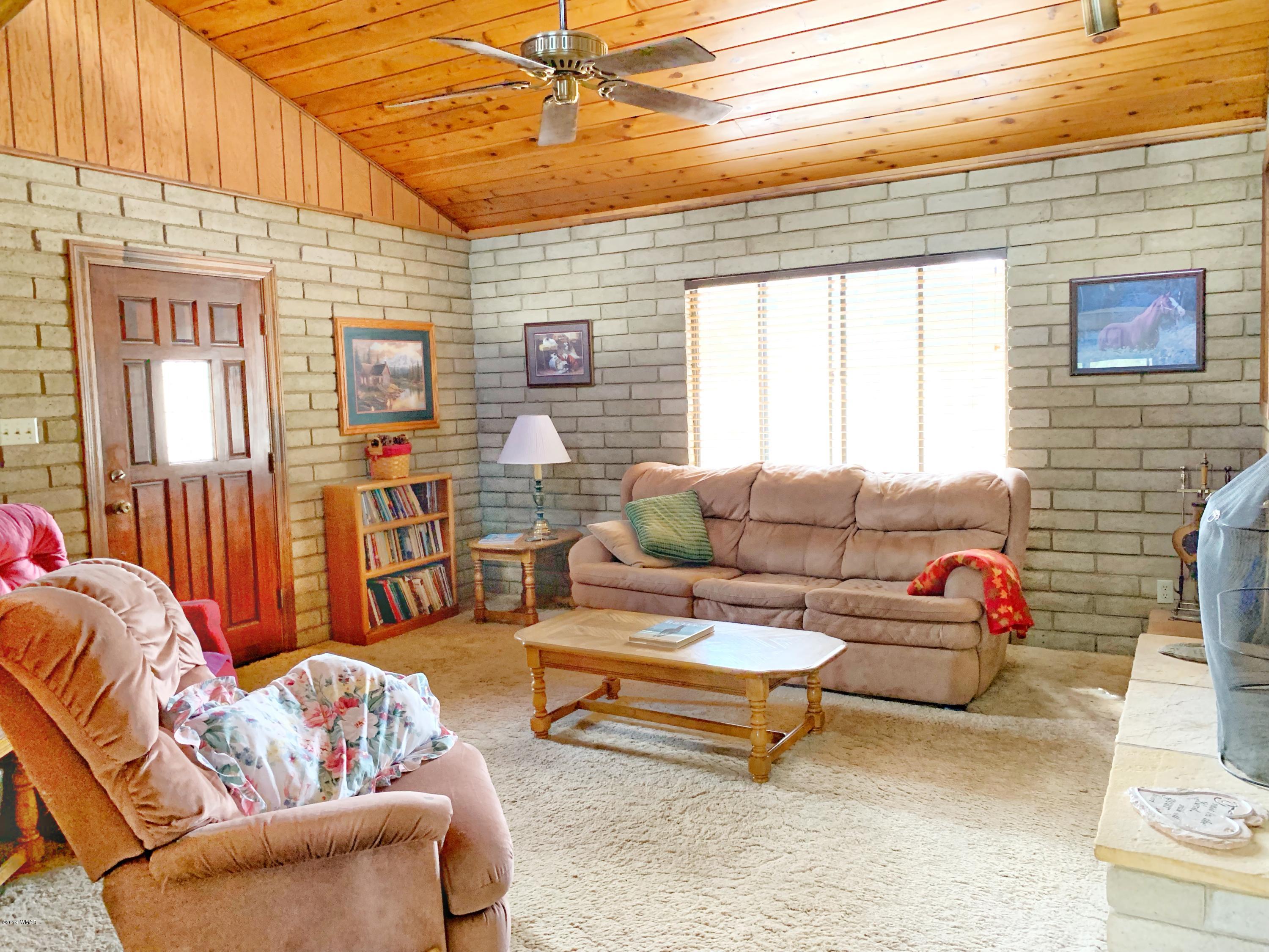 2128 Cottontail Road Overgaard, AZ 85933 - Photo 3 of 18 a living room with furniture a flat screen tv and a window