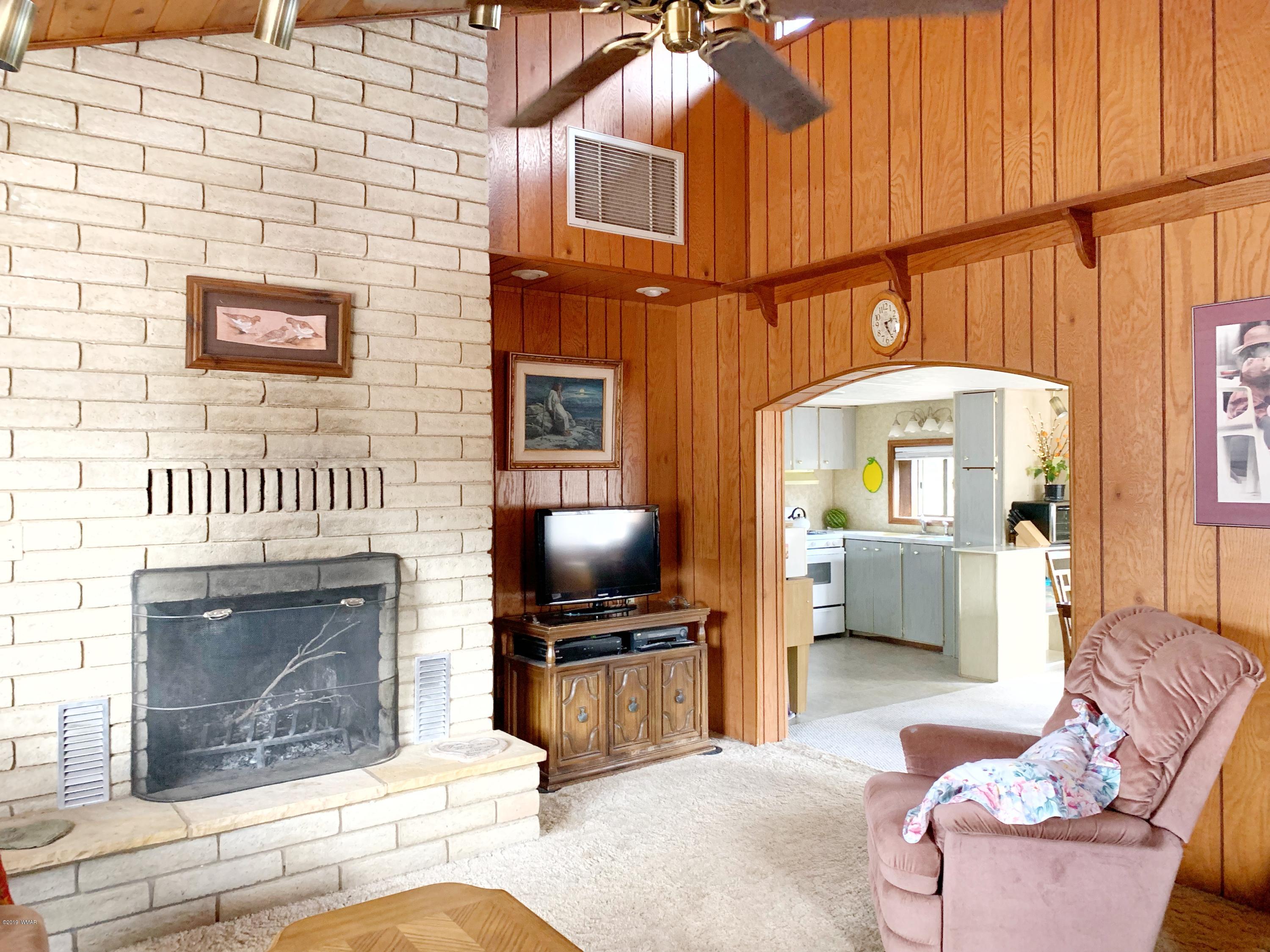 2128 Cottontail Road Overgaard, AZ 85933 - Photo 5 of 18 a living room with furniture a fireplace and a flat screen tv