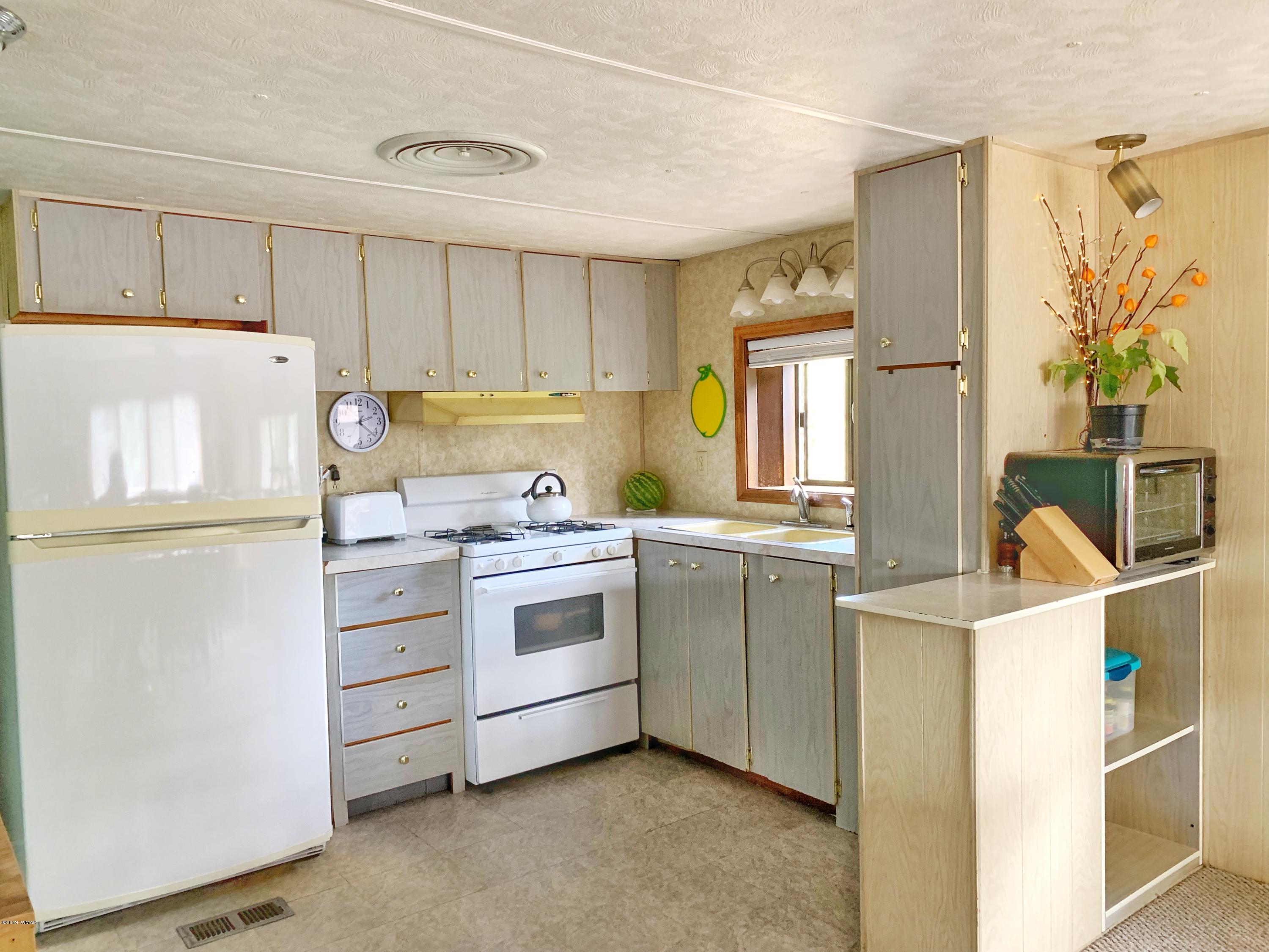 2128 Cottontail Road Overgaard, AZ 85933 - Photo 6 of 18 a kitchen with a refrigerator and a stove top oven