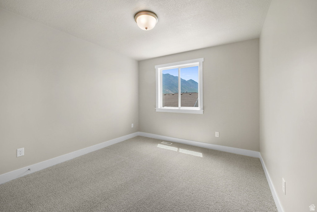 175 West 930 North Santaquin, UT 84655 - Photo 11 of 22 Neutral-toned walls and plush carpeting in a bright room with a single window offering a mountain backdrop