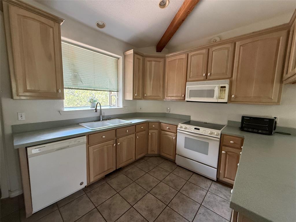 104 Pawnee Trail Gainesville, TX 76240 - Photo 18 of 30 a kitchen with granite countertop cabinets stainless steel appliances a sink and a window
