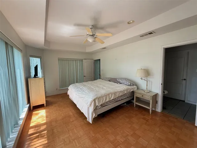 a bed sitting in a spacious bedroom next to a window