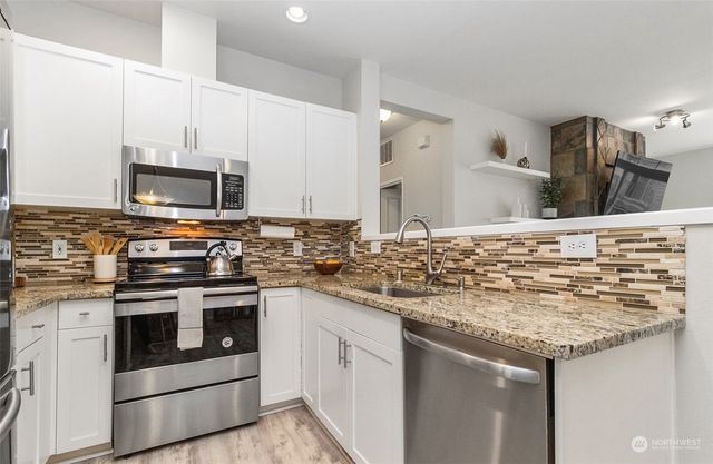 a kitchen with stainless steel appliances granite countertop a stove and a sink