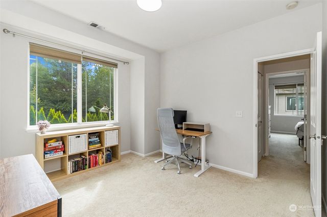 a view of a workspace with furniture and a window