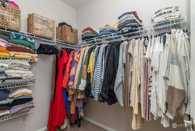 a view of walk in closet with clothes and shoes