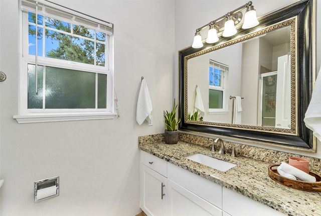 a bathroom with a granite countertop sink and a mirror