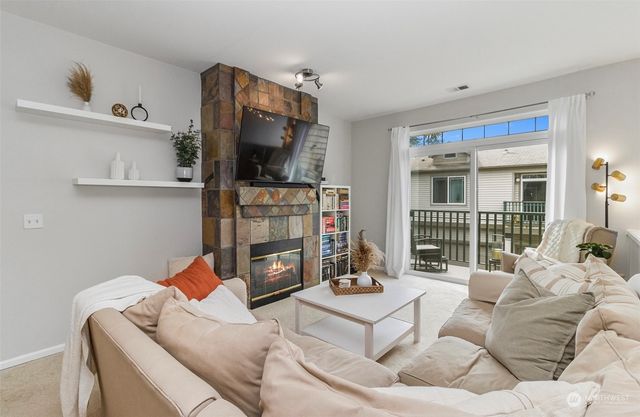 a living room with furniture a flat screen tv and a fireplace