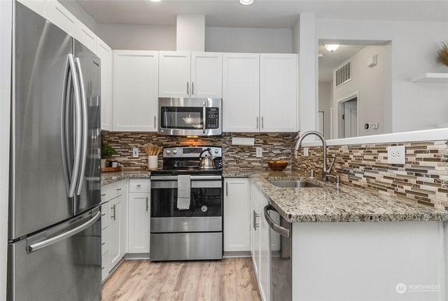 a kitchen with stainless steel appliances granite countertop a refrigerator stove and sink