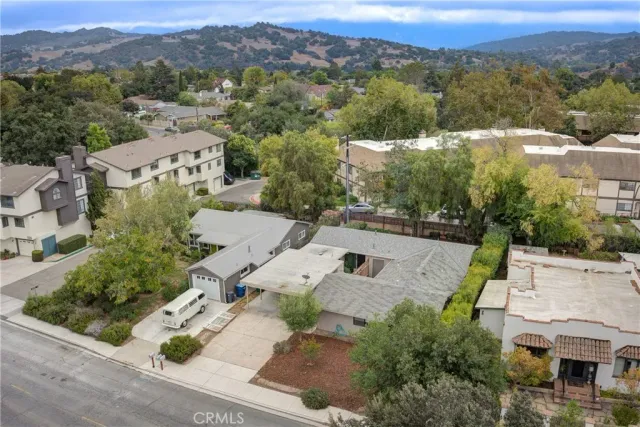 an aerial view of residential houses with outdoor space and mountain view
