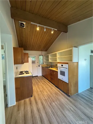 a kitchen with stainless steel appliances granite countertop a large stove a sink dishwasher and a refrigerator with wooden floor