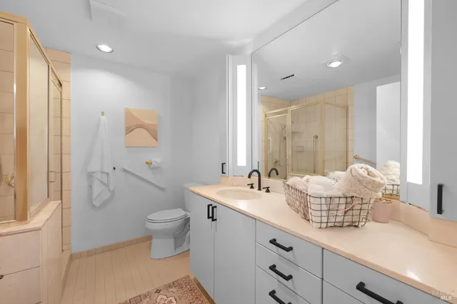 a bathroom with a granite countertop sink a toilet and a mirror
