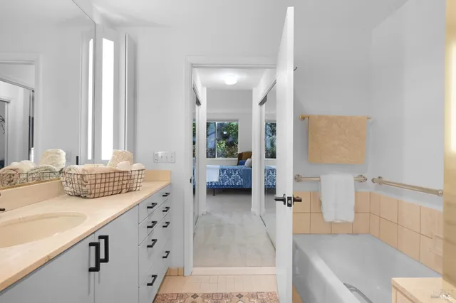 a en suite bathroom with a double vanity sink and a mirror