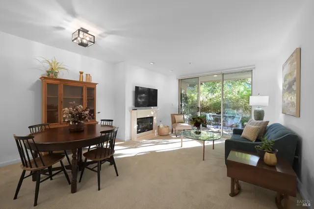 a living room with fireplace furniture and a large window