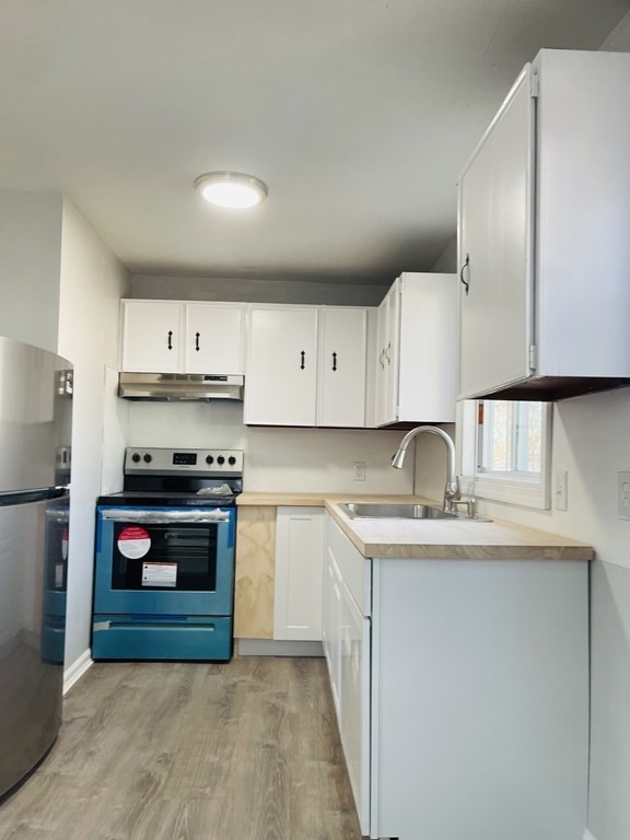 105-107 Parallel Street Springfield, MA 01104 - Photo 5 of 15 a kitchen with stainless steel appliances granite countertop a sink stove and cabinets