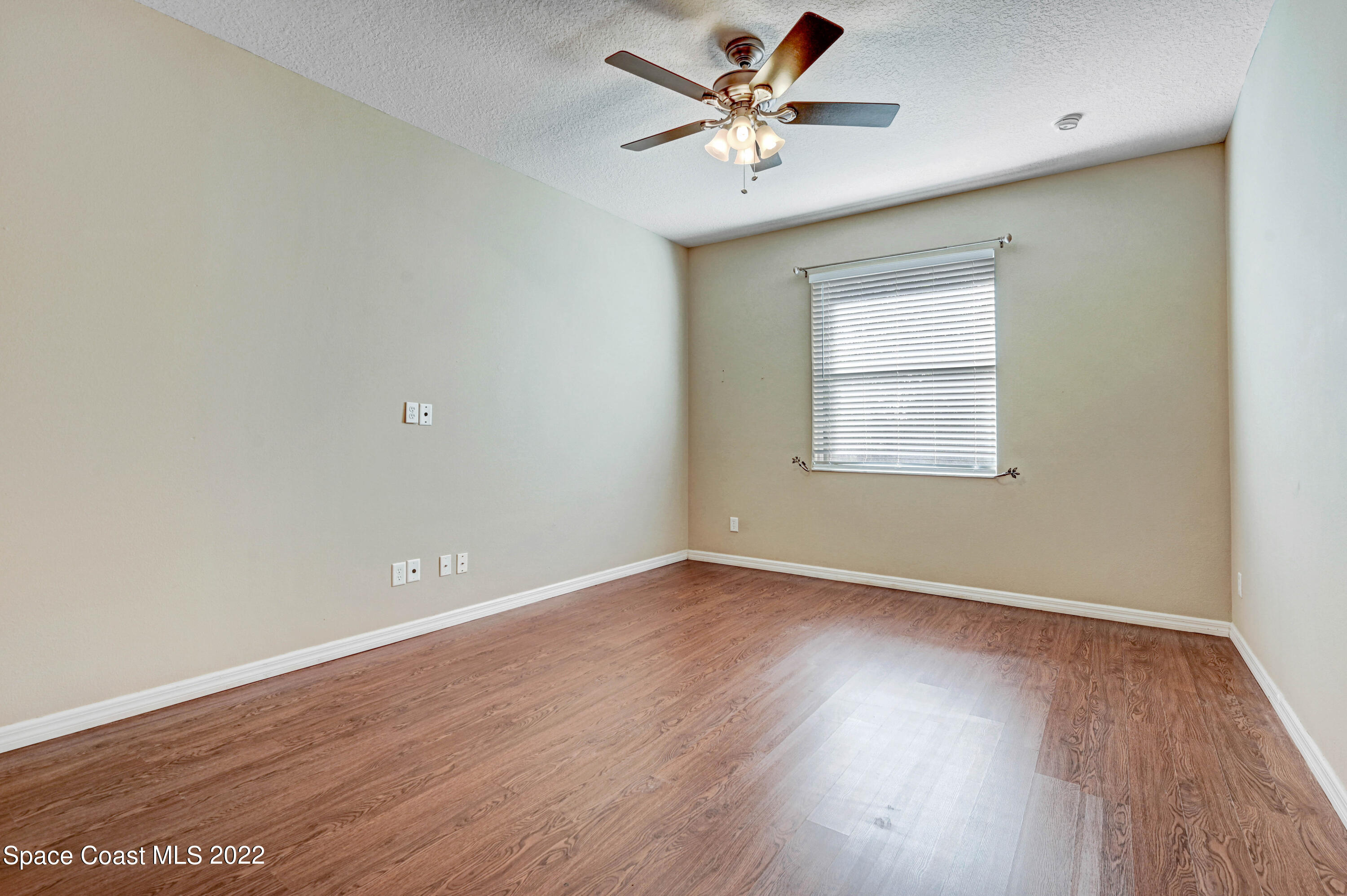 2077 Elkins Point Melbourne, FL 32935 - Photo 15 of 31 an empty room with wooden floor fan and windows