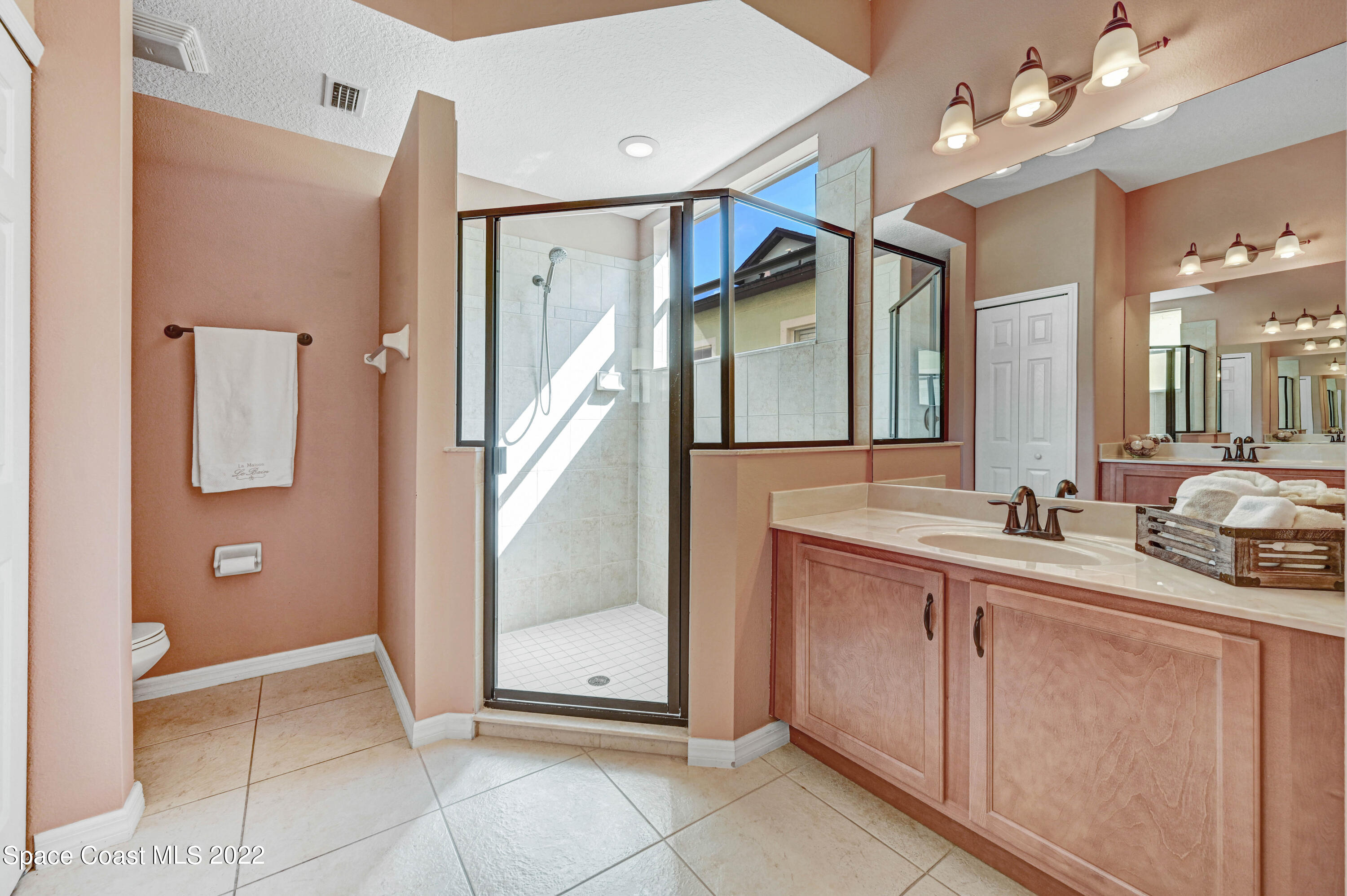 2077 Elkins Point Melbourne, FL 32935 - Photo 16 of 31 a spacious bathroom with a mirror sink and a shower