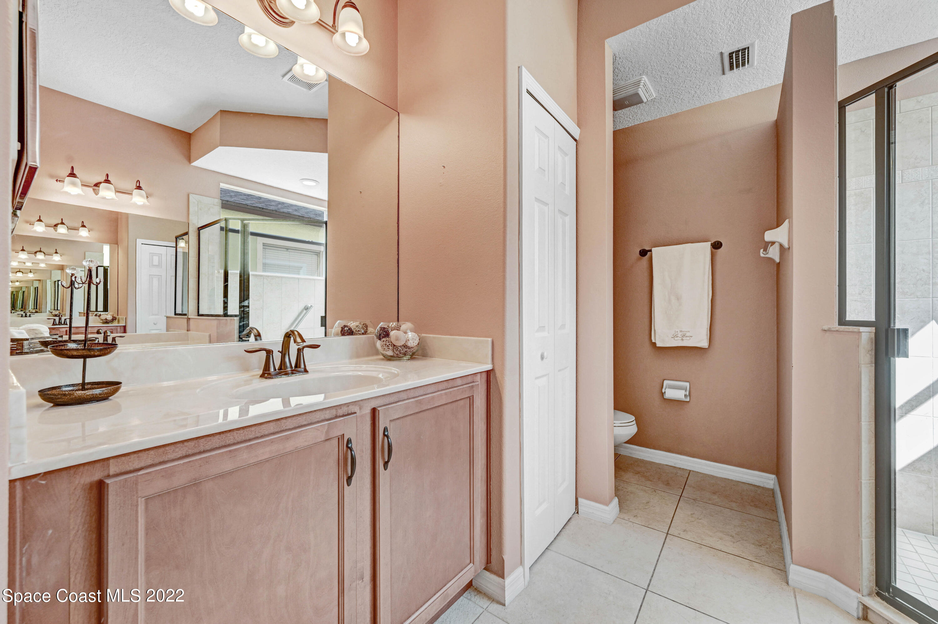 2077 Elkins Point Melbourne, FL 32935 - Photo 17 of 31 a bathroom with a granite countertop sink two mirror and a shower