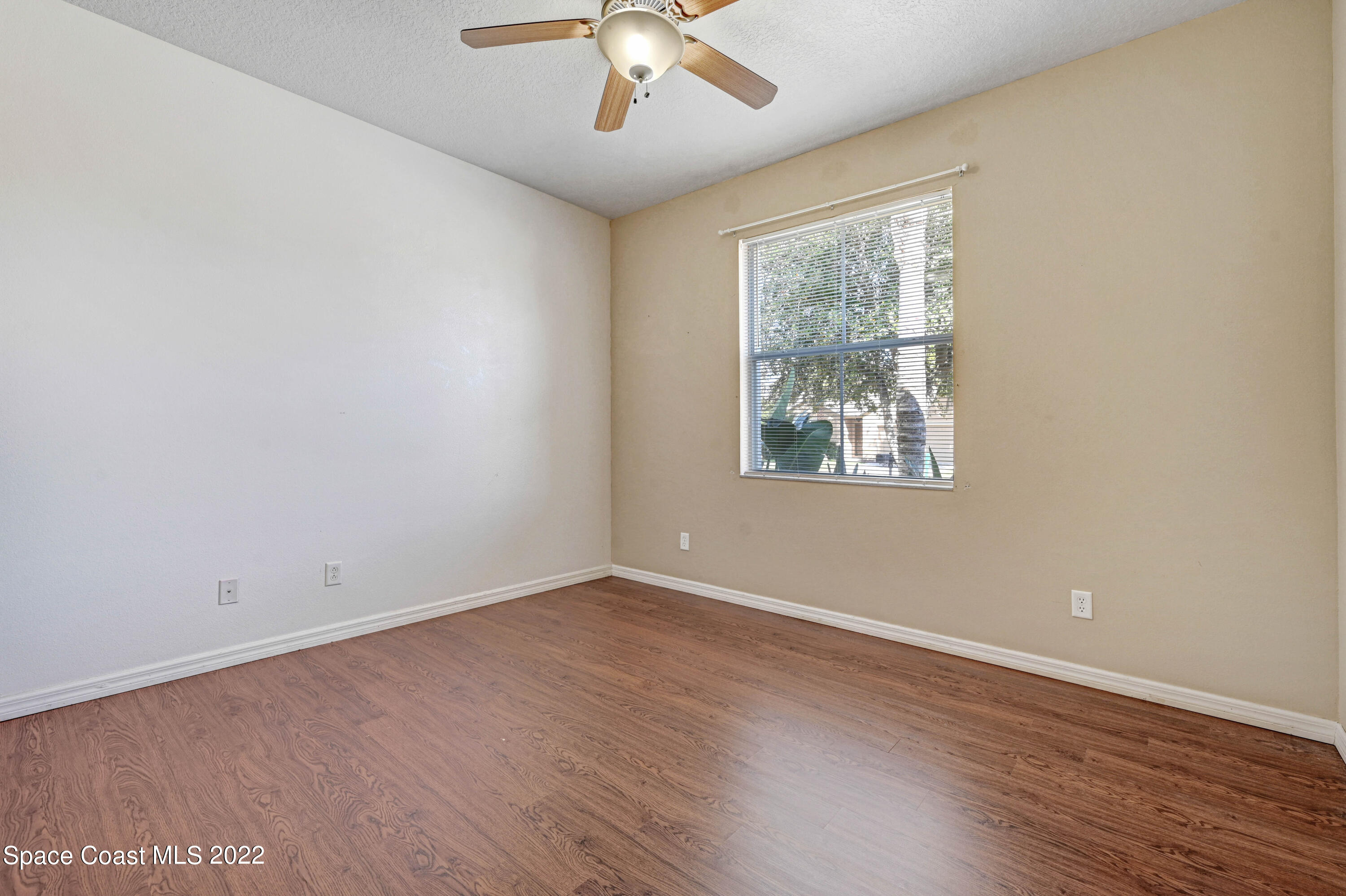 2077 Elkins Point Melbourne, FL 32935 - Photo 22 of 31 an empty room with wooden floor chandelier and windows