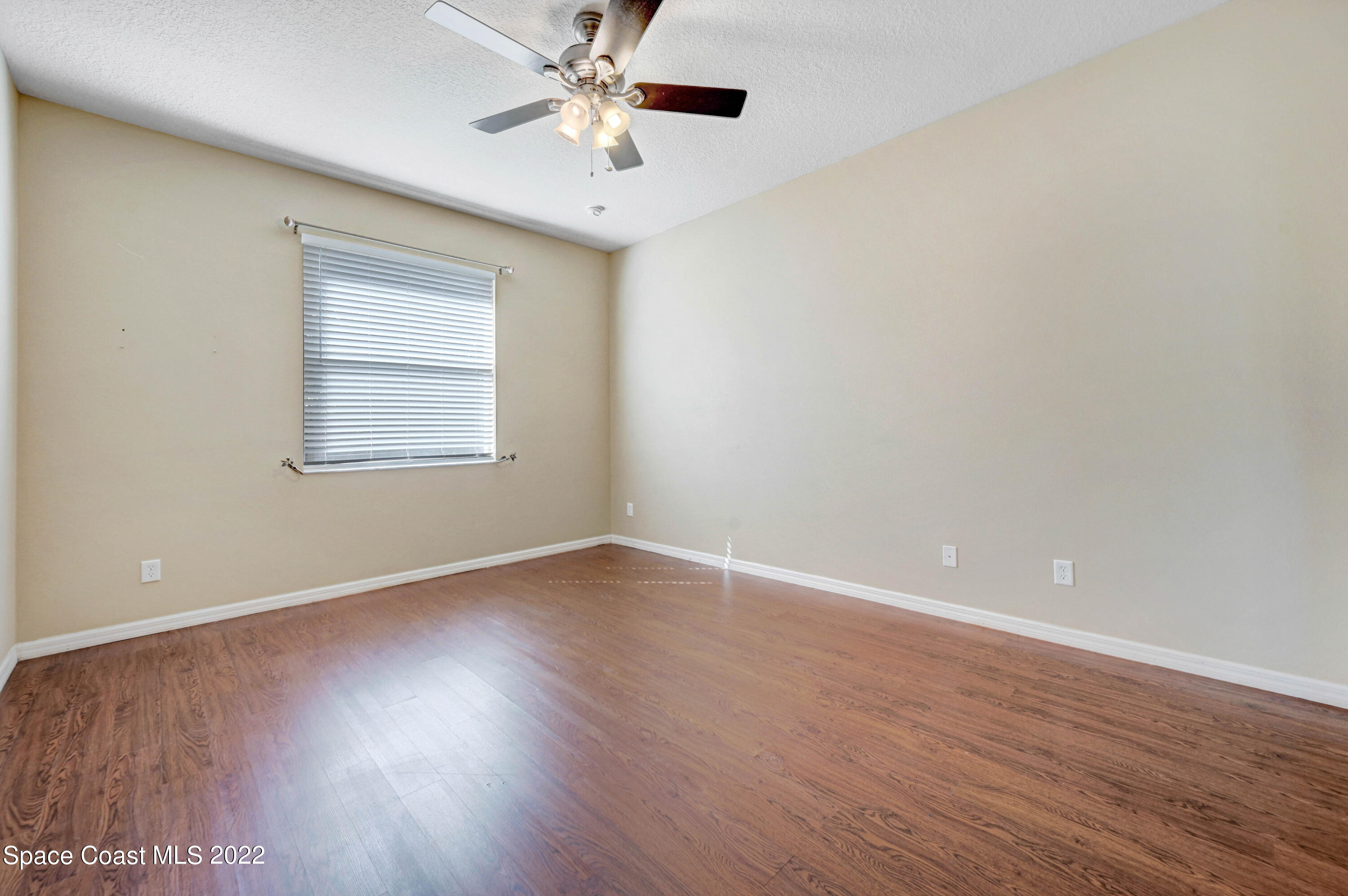 2077 Elkins Point Melbourne, FL 32935 - Photo 23 of 31 an empty room with wooden floor chandelier fan and windows