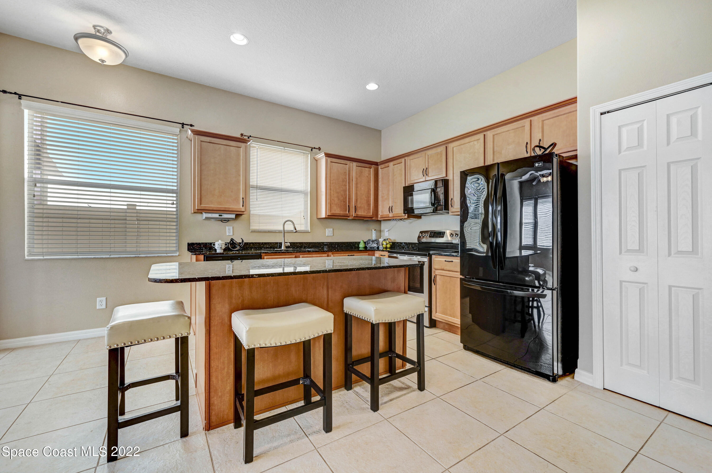 2077 Elkins Point Melbourne, FL 32935 - Photo 9 of 31 a kitchen with stainless steel appliances granite countertop a refrigerator and a stove top oven
