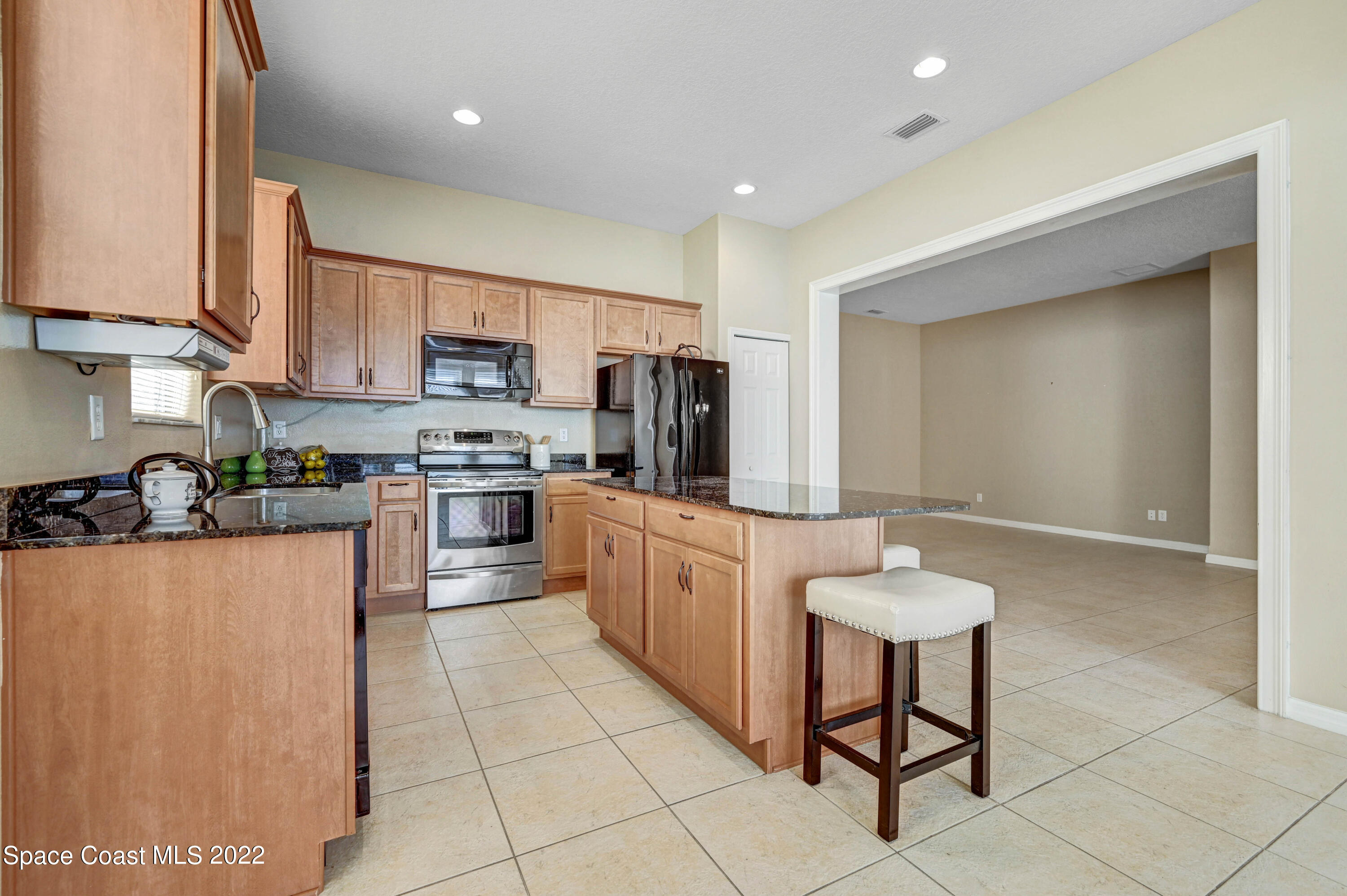 2077 Elkins Point Melbourne, FL 32935 - Photo 10 of 31 a kitchen with stainless steel appliances a refrigerator sink and cabinets