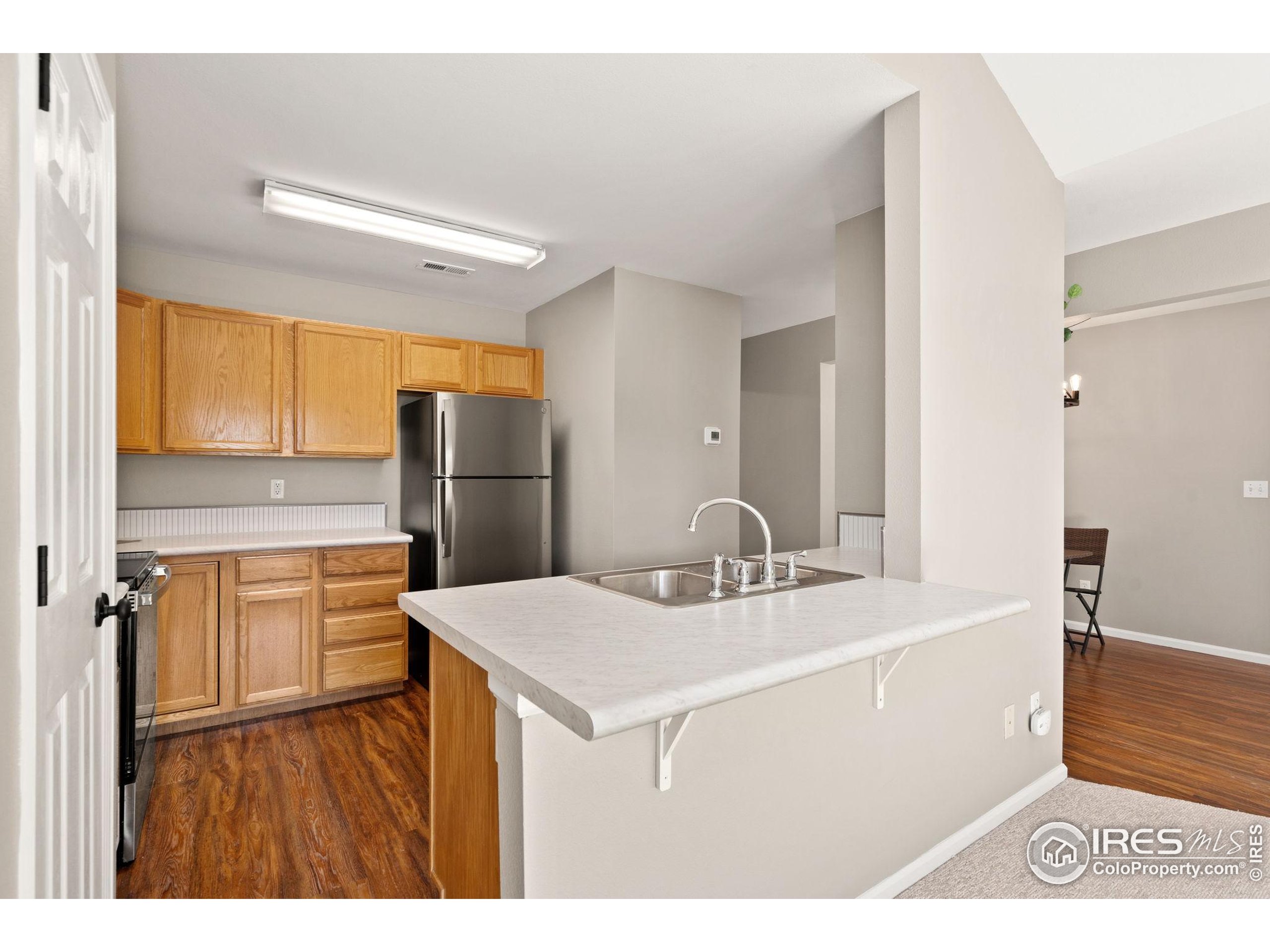 1021 Rolland Moore Drive, Unit F Fort Collins, CO 80526 - Photo 9 of 29 a kitchen with a sink appliances and cabinets