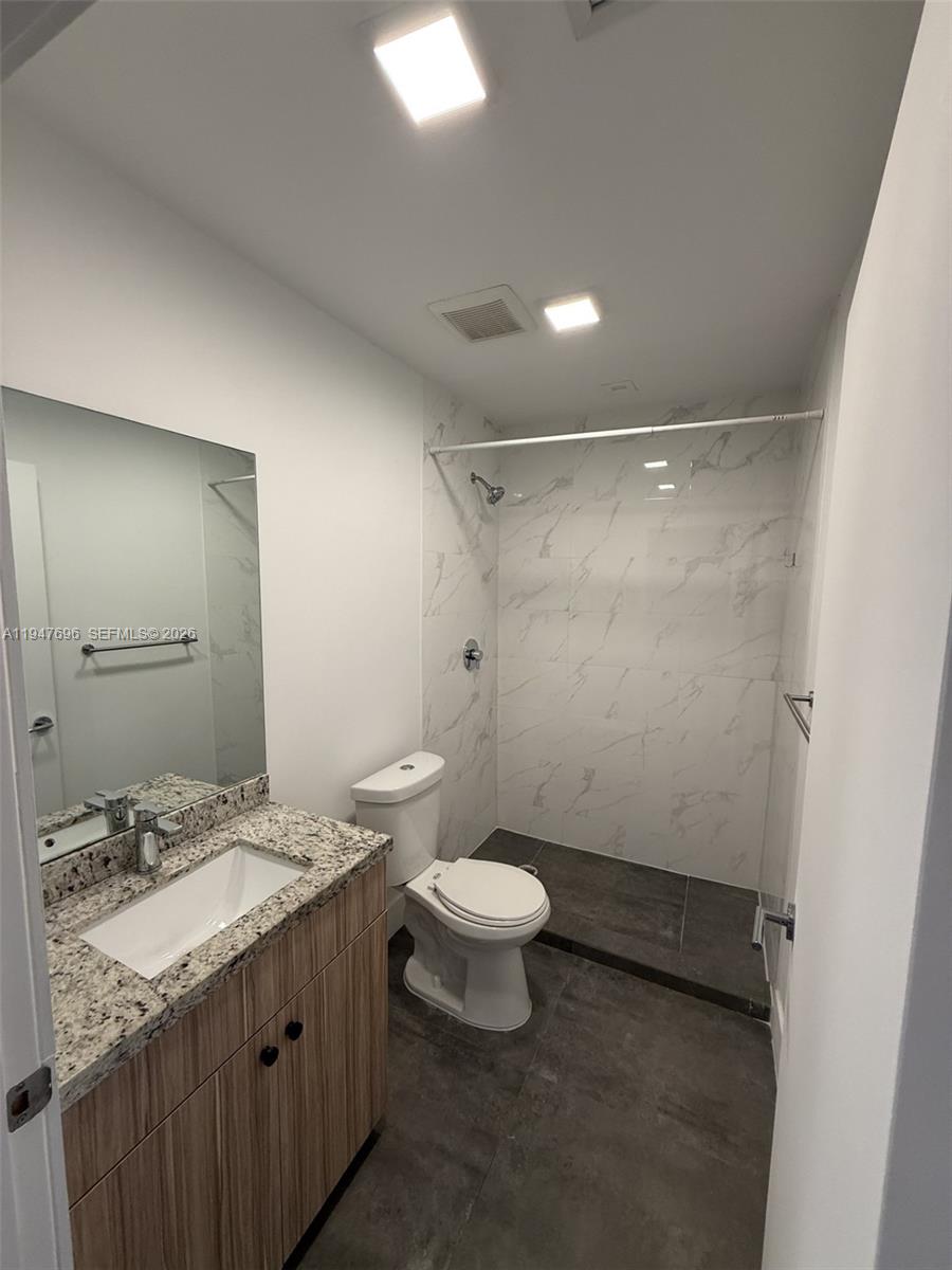 2010 Southwest 25th Terrace, Unit 302 Miami, FL 33133 - Photo 13 of 16 a bathroom with a granite countertop sink toilet and shower