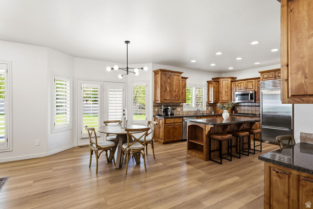 1712 Somerset Ridge Drive Draper, UT 84020 - Photo 16 of 76 Open-concept kitchen and dining area featuring wood-finish flooring, recessed lighting, and a modern chandelier