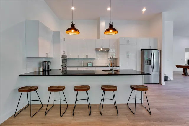 a kitchen with stainless steel appliances granite countertop a refrigerator and a stove top oven