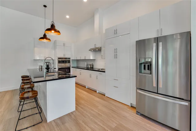 a kitchen with stainless steel appliances a sink a stove and cabinets