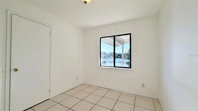 a view of an empty room with window and closet area