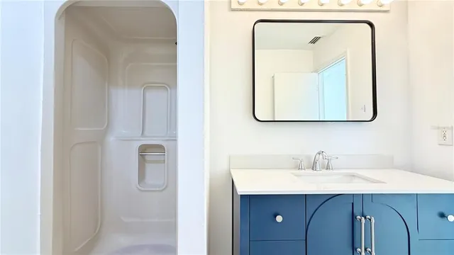 a bathroom with a sink mirror and vanity