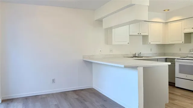 a kitchen with a sink cabinets and white appliances