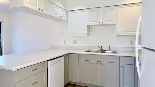 a kitchen with white cabinets and sink