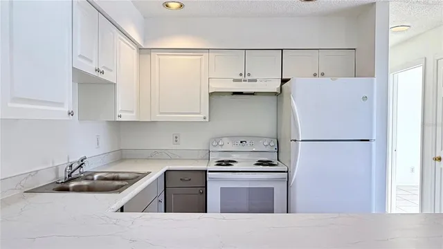 a kitchen with stainless steel appliances a refrigerator sink and cabinets