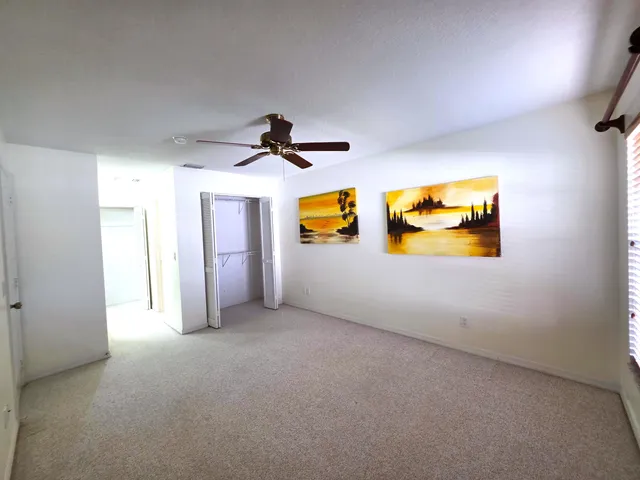 a view of empty room with a ceiling fan and window