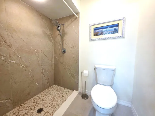 a bathroom with a toilet and a shower