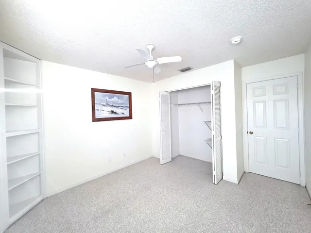 a view of an empty room with a ceiling fan