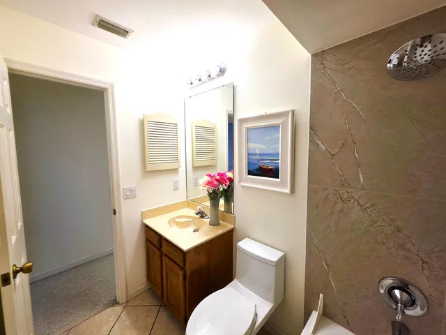 a bathroom with a sink vanity mirror and toilet